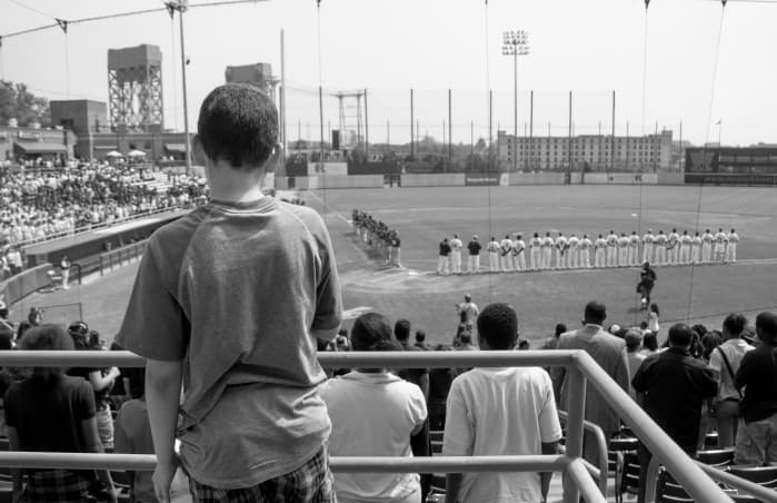 A boy watching a baseball game from the stands